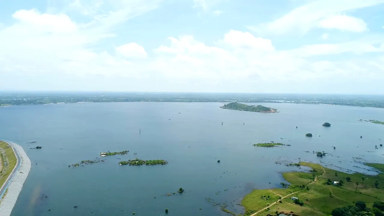 A wide Kaleshwaram reservoir with low islands, seen from the air under a bright sky